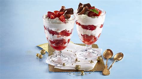 Pohár s vanilkovým pudingom a šľahačkou ozdobený granátovým jablkom a čokoládou