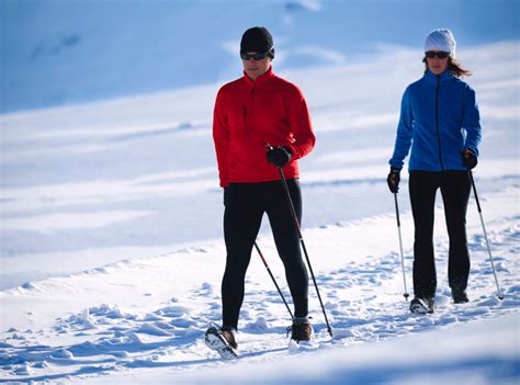Muž a žena idúci na nordic walking v jesennom lese