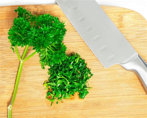 miska s rizotom posypaná parmezánom a ozdobená lístkami petržlenovej vňate