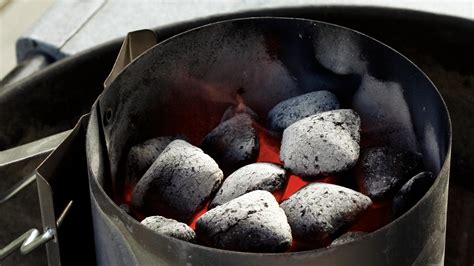 Fľaša s tekutým podpaľovačom a dreveným uhlím pripraveným na zapálenie