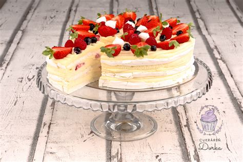 Pavlova torta ozdobená šľahačkou a čerstvým ovocím