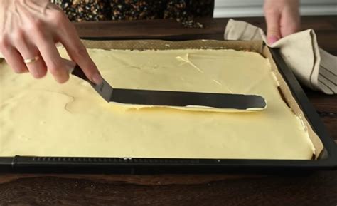 Detail nanášania žĺtkovej polevy na horúci koláč