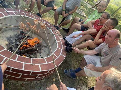 Rodina grilujúca na liatinovom pláte pri ohnisku