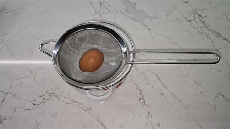 Proces pasírovania uvarených paradajok cez sitko