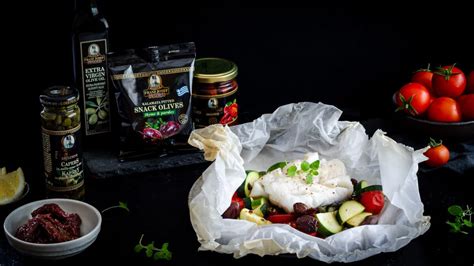 rozložené ingrediencie na rybu s paradajkami a olivami