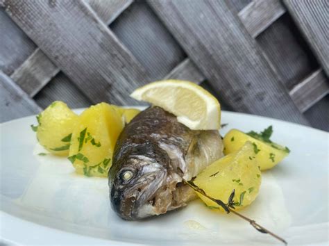 Ilustračná fotografia pečeného pstruha s citrónom a bylinkami