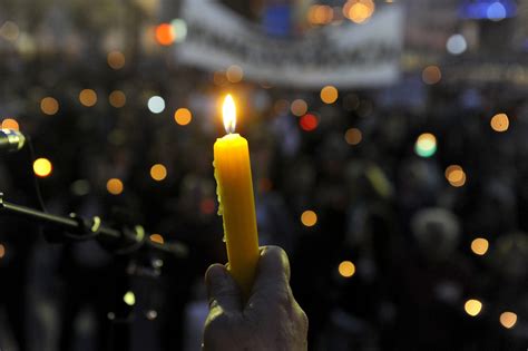 Sviečková manifestácia s ľuďmi držiacimi sviečky