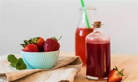 Obrázok fľaše domácej jahodovej šťavy s čerstvými jahodami