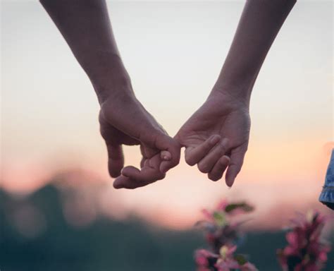 Dvojica držiac sa za ruky pri západe slnka