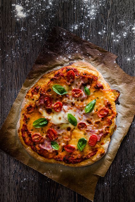 nakrájaná šunka a mozzarella na pripravenom ceste na pizzu