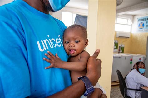 Výživový špecialista UNICEF s podvyživeným dieťaťom na rukách v nutričnom rehabilitačnom centre Dar Naim v Nouakchotte.