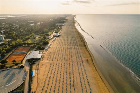 Fotografia pláže v Bibione s lehátkami a slnečníkmi