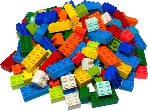 Detská ruka stavia tortu z kociek Lego Duplo
