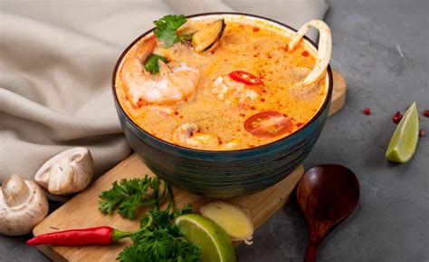 Štýlové fotografie pripravených jedál: kuracie špízy a thajská polievka Tom Yum